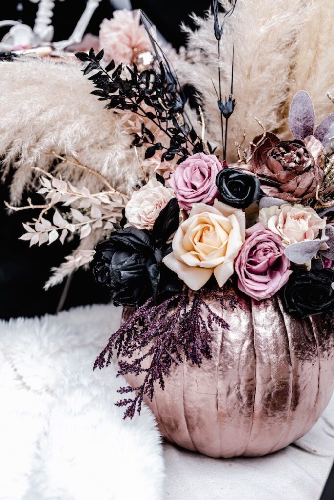 12 Stunning Halloween Florals to Inspire a Spooky Event / A glam Halloween celebration with shiny rose gold pumpkin vases and shades of pink and black flowers